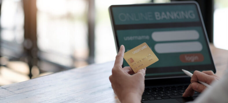 Online payment,woman's hands holding a credit card and using laptop computer for online shopping with vintage filter tone.