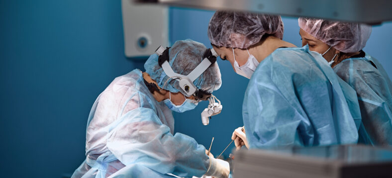 Surgeons and paramedic in mask and operating patient, a professional team of doctors in a modern operating room.